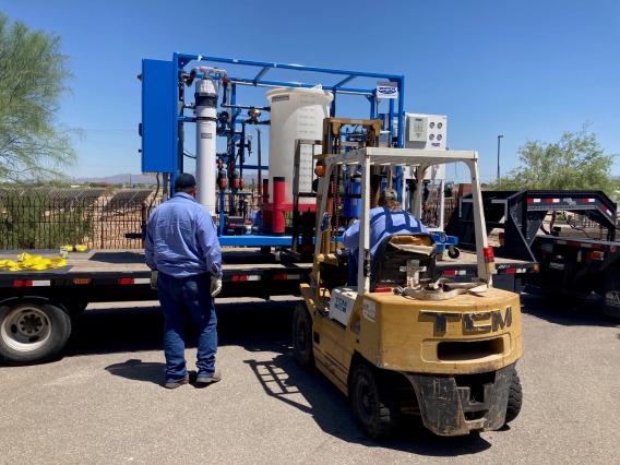 Water reuse equipment on truck bed being lifted off by forklift