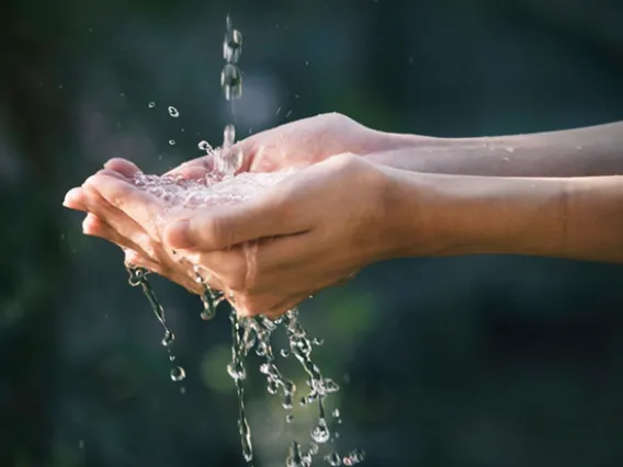 Water running through outstretched hands