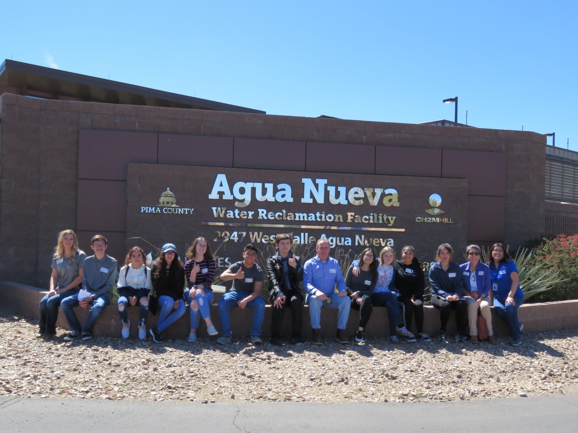 Group of people posing for a photo in front of Agua Nueva Water Research Facility sign