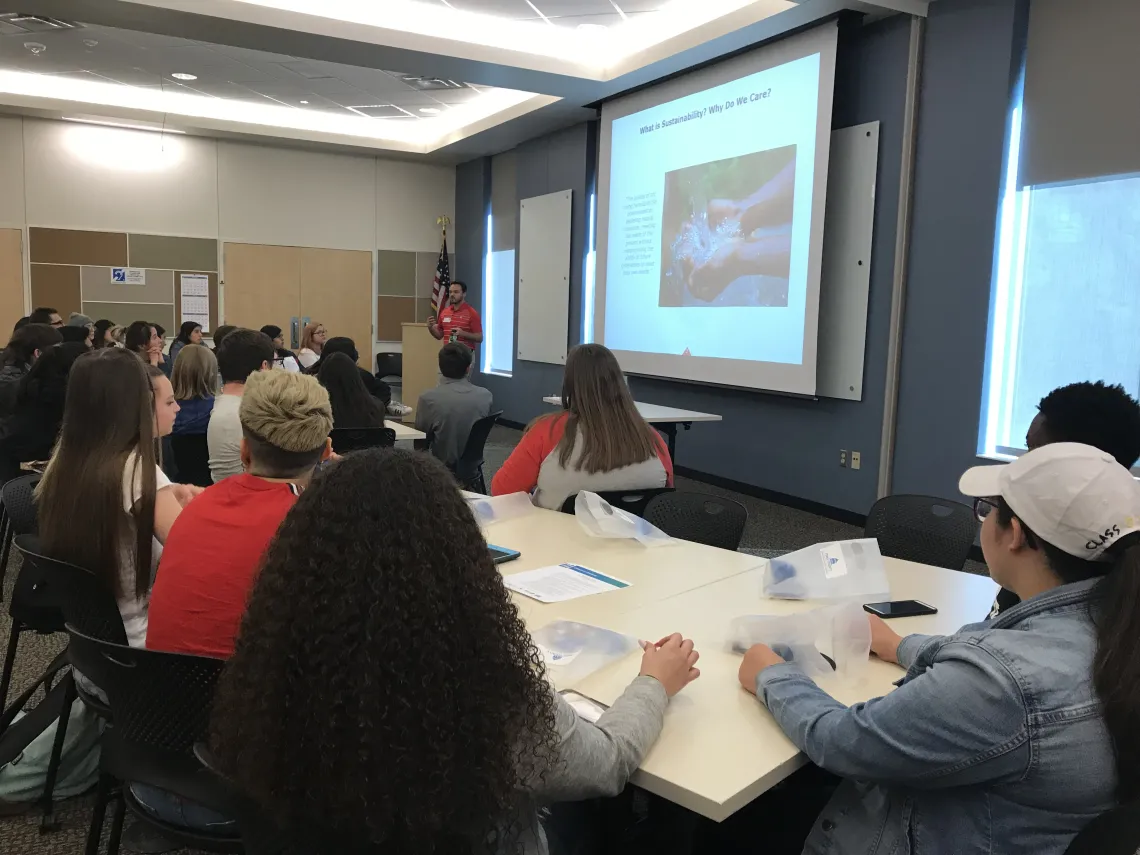 People viewing a power point presentation on a projector at WEST Center