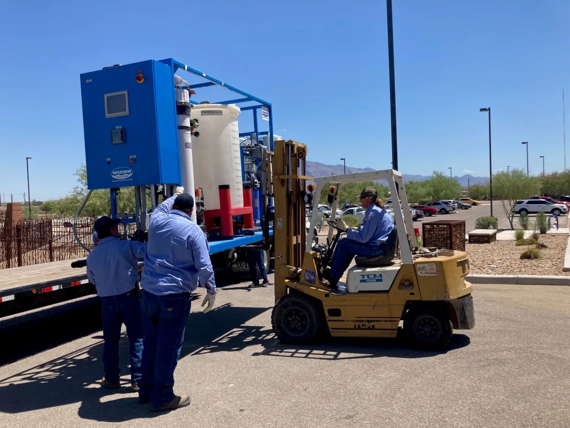 Water reuse equipment on truck bed being lifted off by forklift