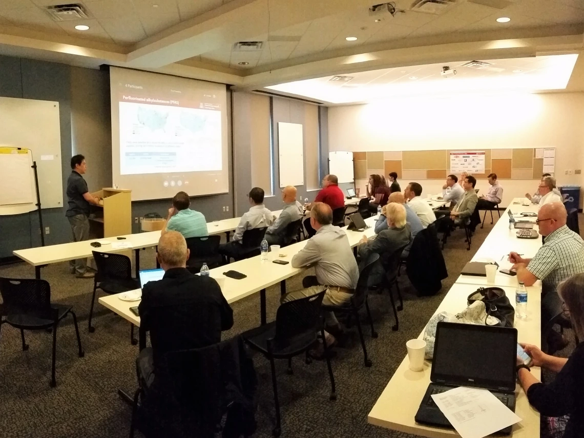 Presentation being given in conference room to an audience of people