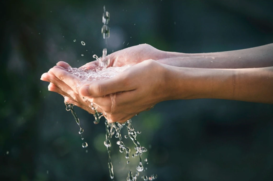 Water running through outstretched hands