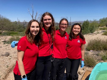 Four students outdoors in red shirts