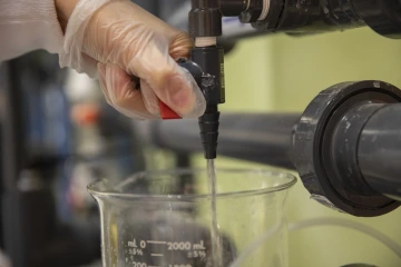 Beaker being filled with water from a filtration system