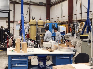 Two researchers in a laboratory high bay space