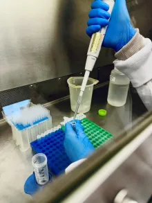 Technician titrating solution into a vial in a laboratory